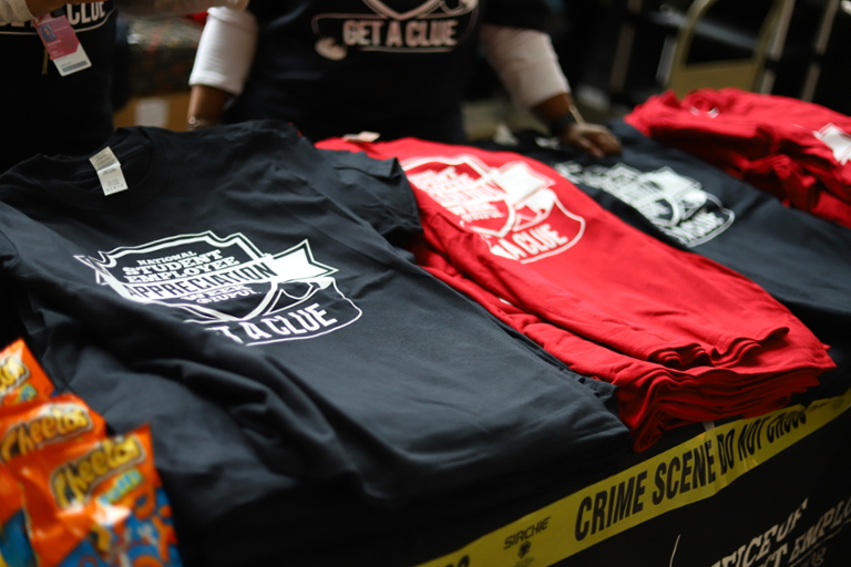 A table with black and red National Student Employment Week T-shirts.